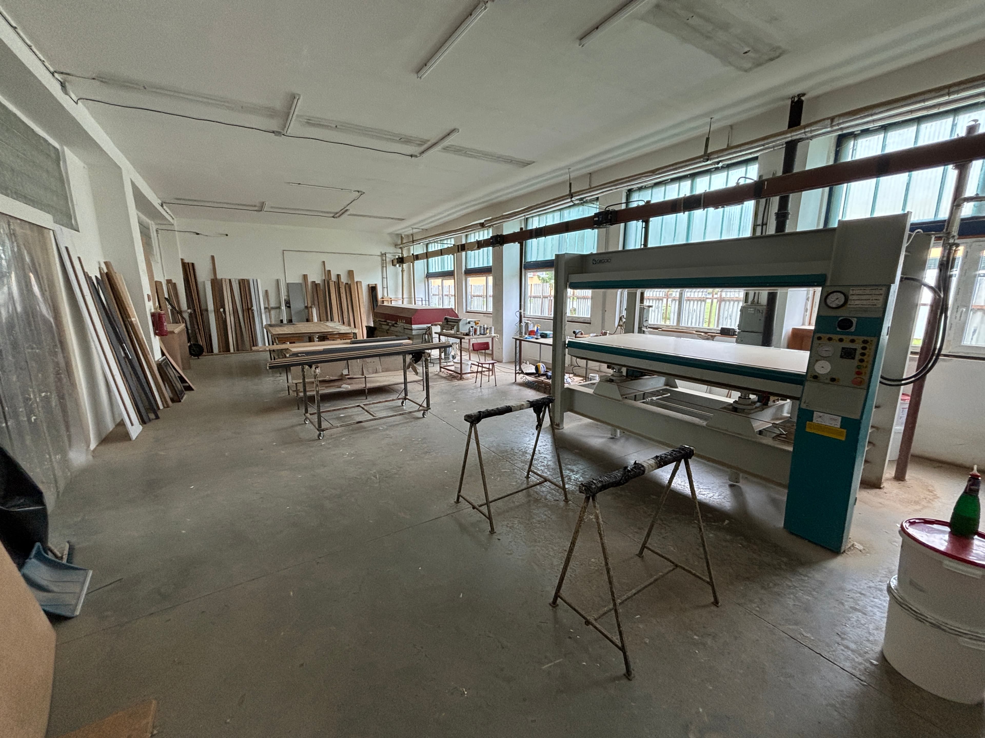 Wide view of the workshop with lumber racks and a hot press